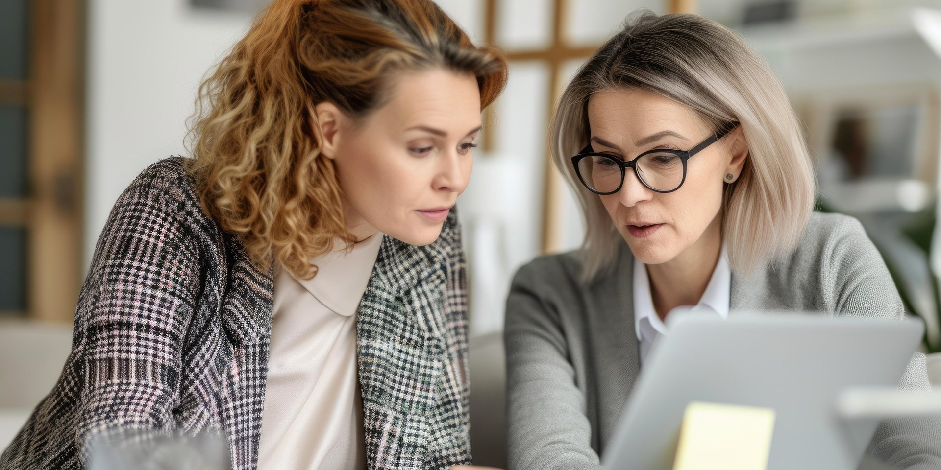 Two colleagues reviewing and analysing a project together on a laptop